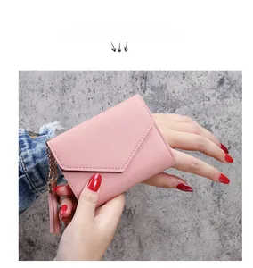 Pink lychee grain faux leather tri-fold wallet featuring a stylish metal tassel pendant