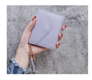Detail of lavender litchi pattern wallet with gold ring tassel on stone background
