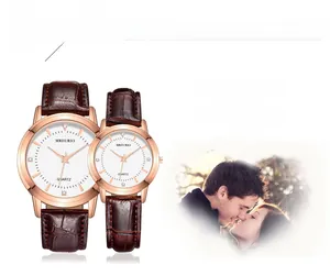 Gros plan de montres couple à quartz or rose avec bracelets cuir brun et cadran blanc