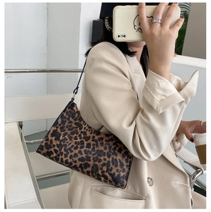 Detail view of stylish leopard print shoulder bag worn with a white blazer