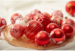 Macro detail of red Christmas ornaments with snowflake patterns on an amber glass tray