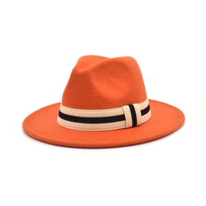 Detailed view of orange wool fedora hat with black and white striped ribbon band