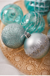 Detailed view of mint green and silver Christmas ball ornaments with varied textures
