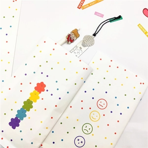 Detail of white paper gift bag with colorful flower patterns and cute emoji icons