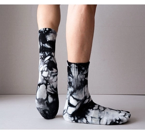 Detail of black and white tie-dye cotton crew socks on feet with street style aesthetic