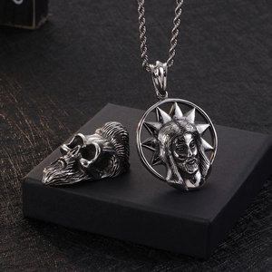 Detail of beard skull and Jesus head pendants in polished stainless steel for men