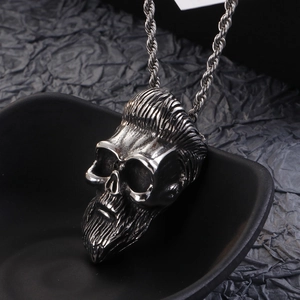 Detailed close-up of a bearded skull pendant in vintage silver on a textured background