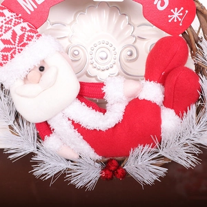 Christmas wreath with plush Santa doll, rustic rattan base, and red ball ornaments