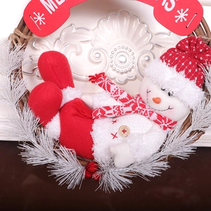 Christmas snowman wreath with red Merry Christmas sign on white pine needles and rattan ring