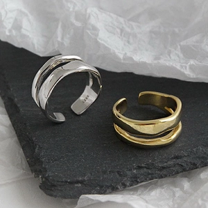 Macro detail of irregular S925 sterling silver open rings on stone and art paper