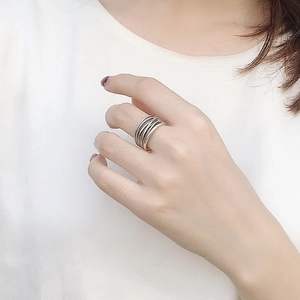Macro view of vintage silver textured multi-layer braided ring on a model hand