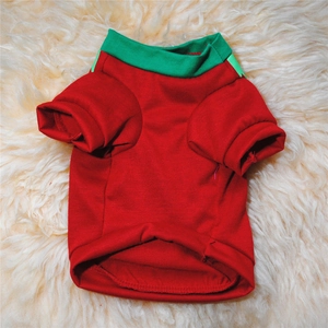 Detail of red Christmas dog sweater with green ribbed neckline on white plush background