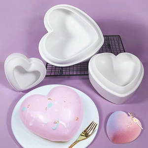 Hartvormige siliconen mousse cakevorm set met roze geglazuurd dessert op bord