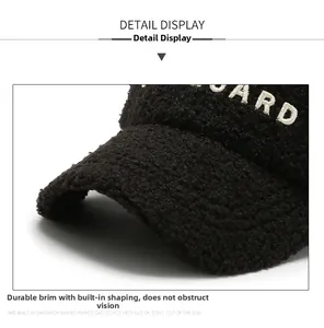 Detailed close-up of the black fuzzy fleece baseball cap with white embroidered letters