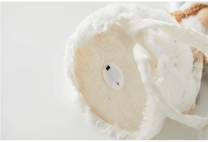 Close-up of the plush angel ornament base showing battery compartment and power switch