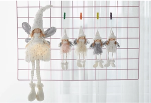Close-up of plush angel dolls with sequin wings in white pink and grey Christmas decor