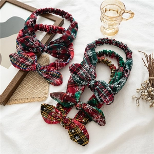 Detail of red and green plaid Christmas headbands with snowflake patterns and bows