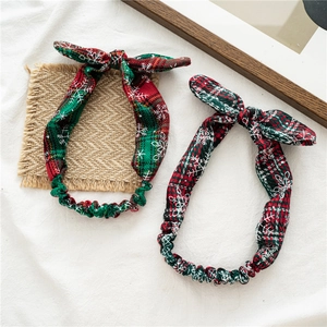 Close-up of red and green plaid bow headbands with white snowflake patterns