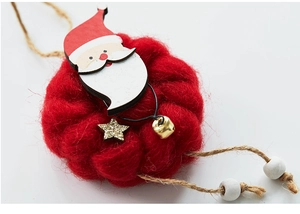 Detail of wool felt Christmas ornament with Santa Claus wooden figure and small bell