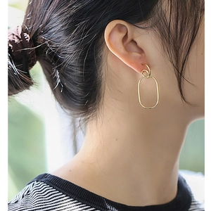 Elegant gold geometric earrings featuring layered oval metal rings on model