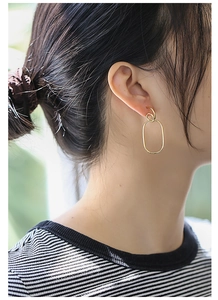 Detail of gold geometric double hoop earrings on model showing minimalist line design