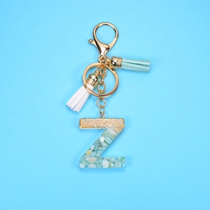 Detailed view of resin letter Z keychain with blue stones, gold foil and colorful tassels