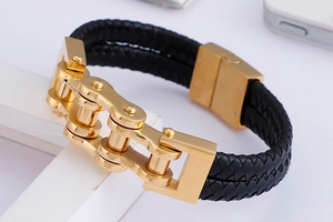 Detail of gold mechanical chain links paired with black double braided leather on the bracelet