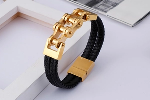 Detail of black braided leather bracelet with golden stainless steel bike chain link