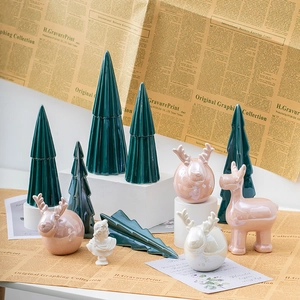 Pink and green ceramic Christmas tree and elk figurines set on vintage paper background