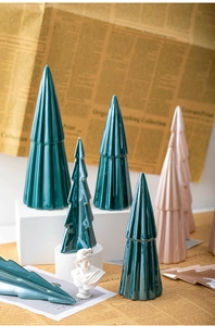 Detail of pink and green ceramic Christmas trees with ribbed texture on vintage paper