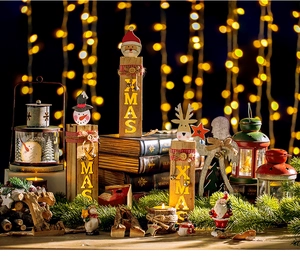 Close-up of wooden XMAS ornaments with Santa and snowman figurines and warm bokeh light