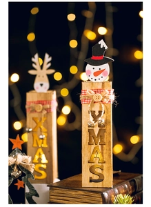 Close-up of wooden Reindeer and Snowman ornament on vintage books with festive bokeh lights