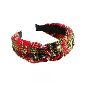 Macro detail of Christmas headband with red and yellow tartan fabric and snowflake patterns