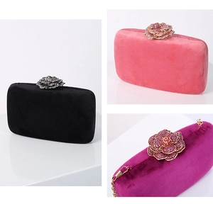 Three velvet clutch bags in black and pink with crystal-embellished flower clasps