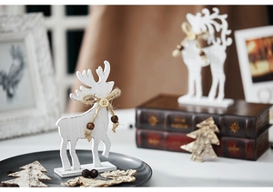 Close-up of white wooden reindeer figures with rustic rope and bead details for holiday decor