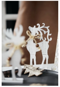 Close-up of white wooden reindeer decoration with jute bow and rustic bead details