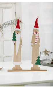 Detail of hand-painted wooden Santa and Snowman Christmas tree ornaments on a table