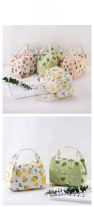 Close-up of insulated canvas lunch bags with fruit prints and white woven handles