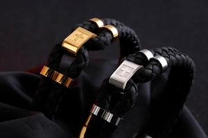 Macro view of woven leather texture and polished stainless steel cross charm bracelets