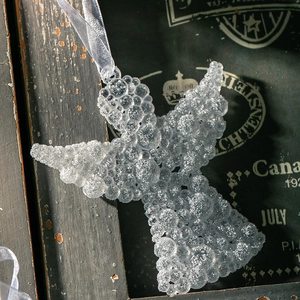 Funkelnder Weihnachtsengel Anhänger aus weißem Acryl mit Glitzer auf dunklem Holzhintergrund