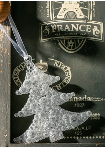Makroaufnahme von silbernem Glitzer-Christbaumschmuck mit eleganter grauer Seidenkordel