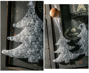 Detailansicht von Acryl-Weihnachtsbaumanhänger mit Silberglitzer auf Vintage-Hintergrund