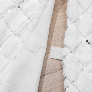 Detail of silver sequins on white faux fur Christmas tree skirt with velcro closure