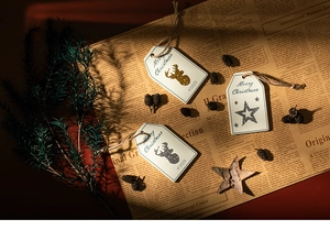 Close-up of Merry Christmas wooden tags with reindeer and stars on vintage newsprint