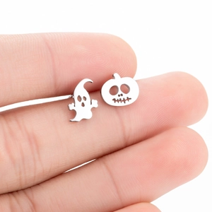 Detailed close-up of silver ghost and pumpkin stud earrings for Halloween theme