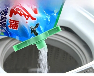 Green plastic sealing clip with pour spout pouring detergent into a washing machine