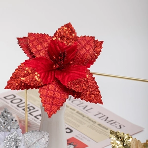 17cm sparkling red poinsettia Christmas flower with gold sequins and festive newspaper background