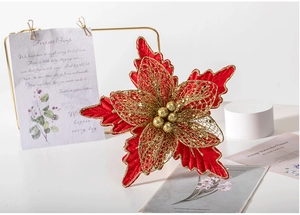 Macro view of a 24cm red and gold poinsettia Christmas flower with festive decorations