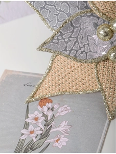 Close-up of 26cm burlap Christmas flower with silver sequins and gold bead center