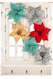 Glittering artificial poinsettia flowers in red and gold on vintage wooden window decor